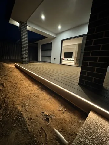 Warm strip lighting run along the edge of a new timber deck with downlit alfresco ceiling