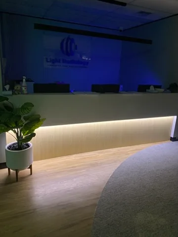 Backlit reception sign and a strip light under the curved counter of a radiology clinic