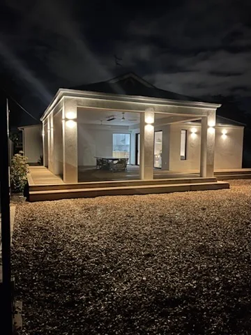 Soffit and column downlights lighting the front verandah of a rendered Adelaide home at night