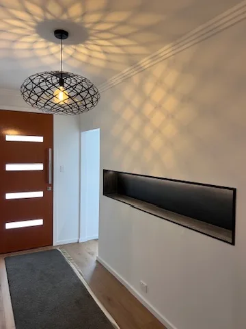 Caged pendant throwing a web of light across the ceiling of an entry hall